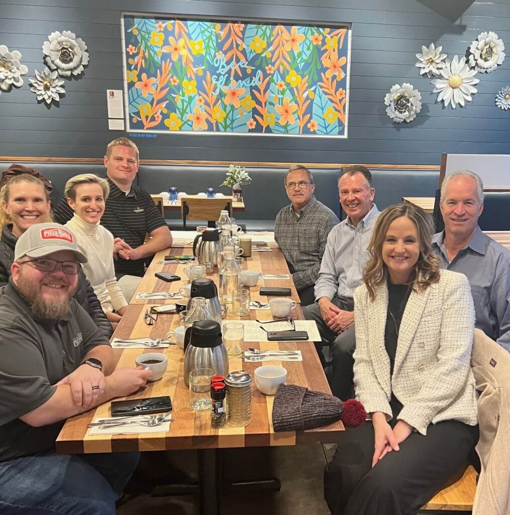 people smiling seated at a long table