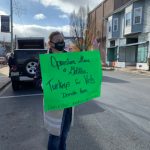 Alice holding sign outside for Operation Give a Gobbler
