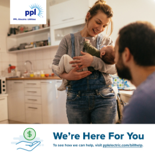 woman holding baby with husband looking on in the kitchen