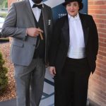 Man with bowler hat and cigar with woman in top hat and tails