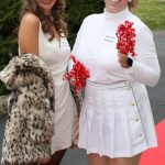 Woman in white holding fur jacket with cheerleader