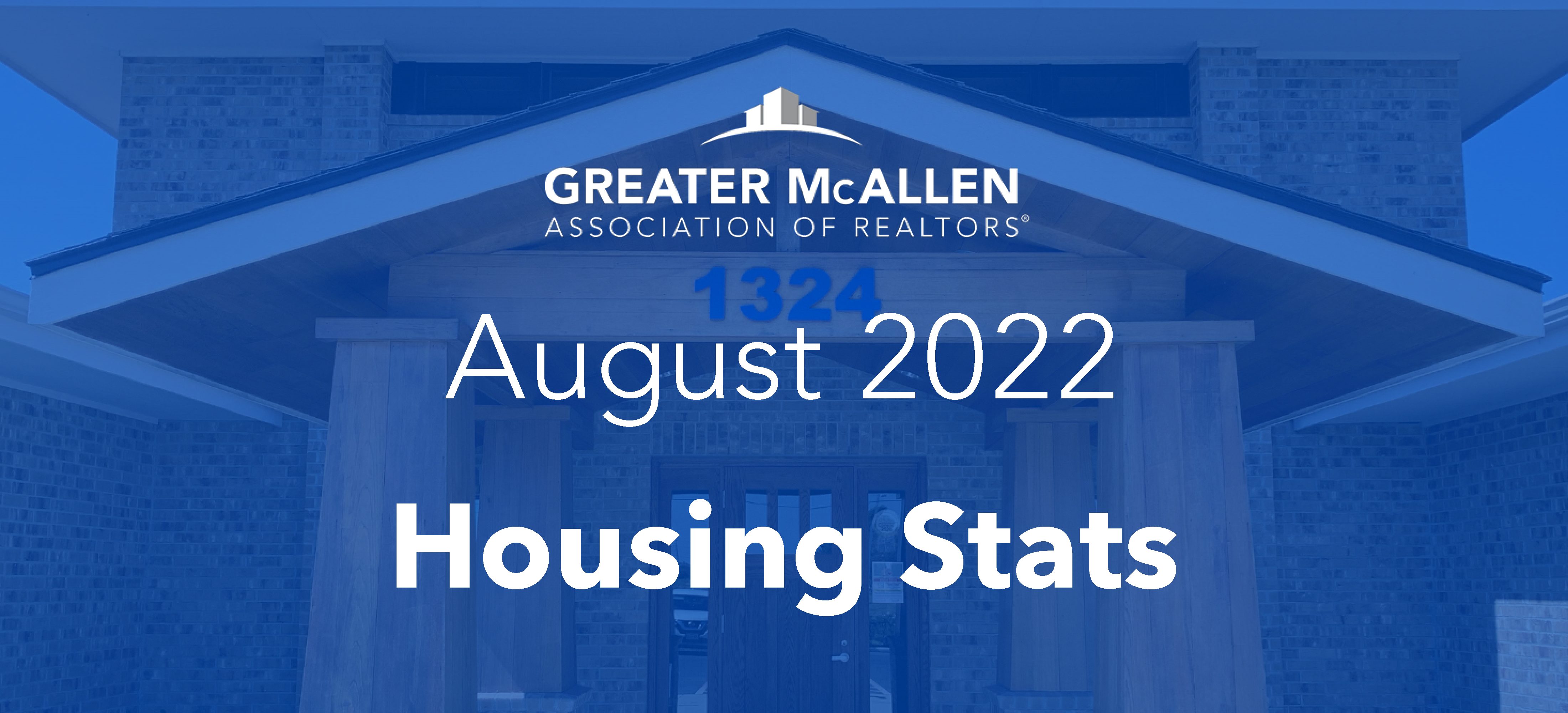 Graphic reading August 2022 Housing Stats on a transparent blue overlay atop a photo of a brick building