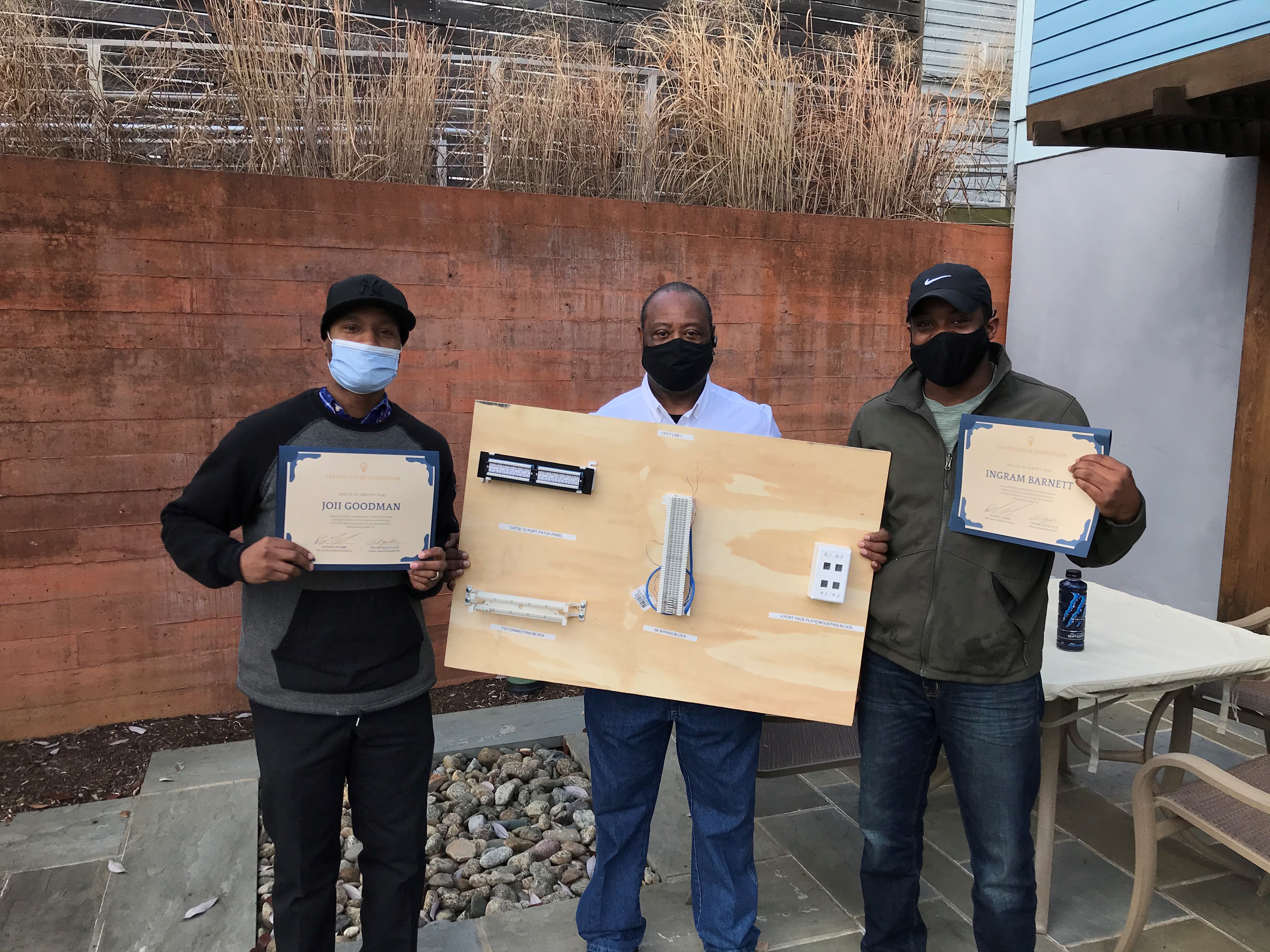 Network2Work participants Joii Goodman and Ingram Barnett pose with instructor Daniel Clark after completing the Certified Premises Cabling Technician (CPCT) course for fiber optic network installation.