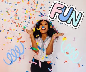 A young women standing in a rain of confetti. There are colorful graphic spirals on either side, and the word "Fun"  above her  head in a cartoon-like graphic. End Description.