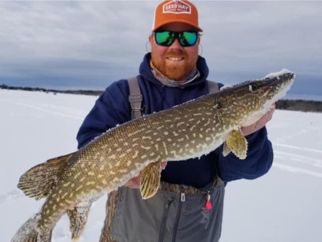 ice fisherman holding fish