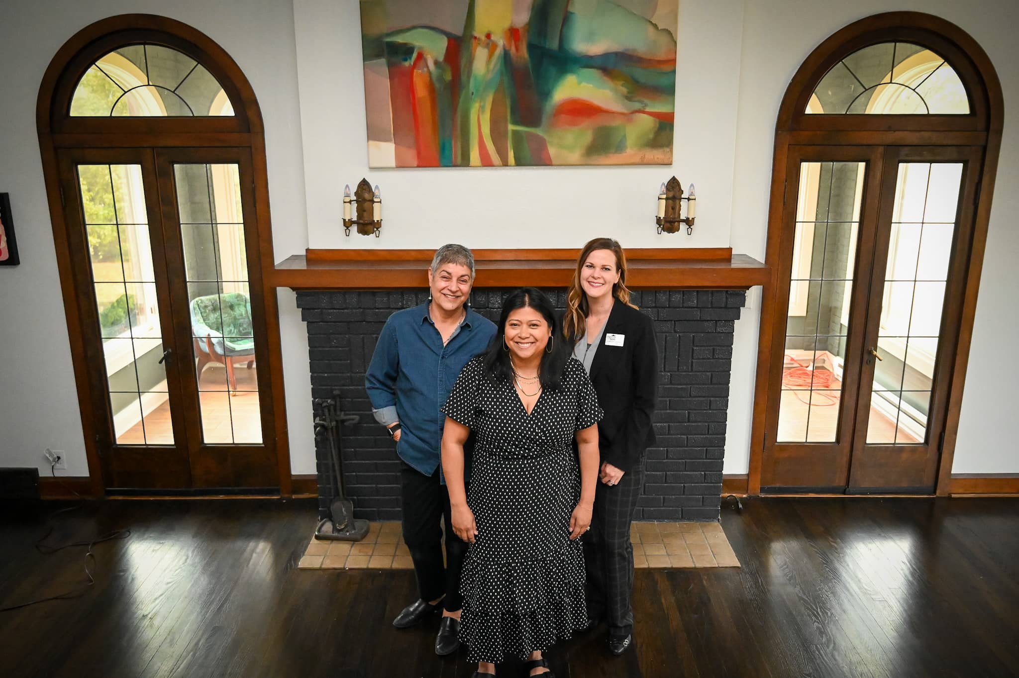 three women in front of brick fireplace