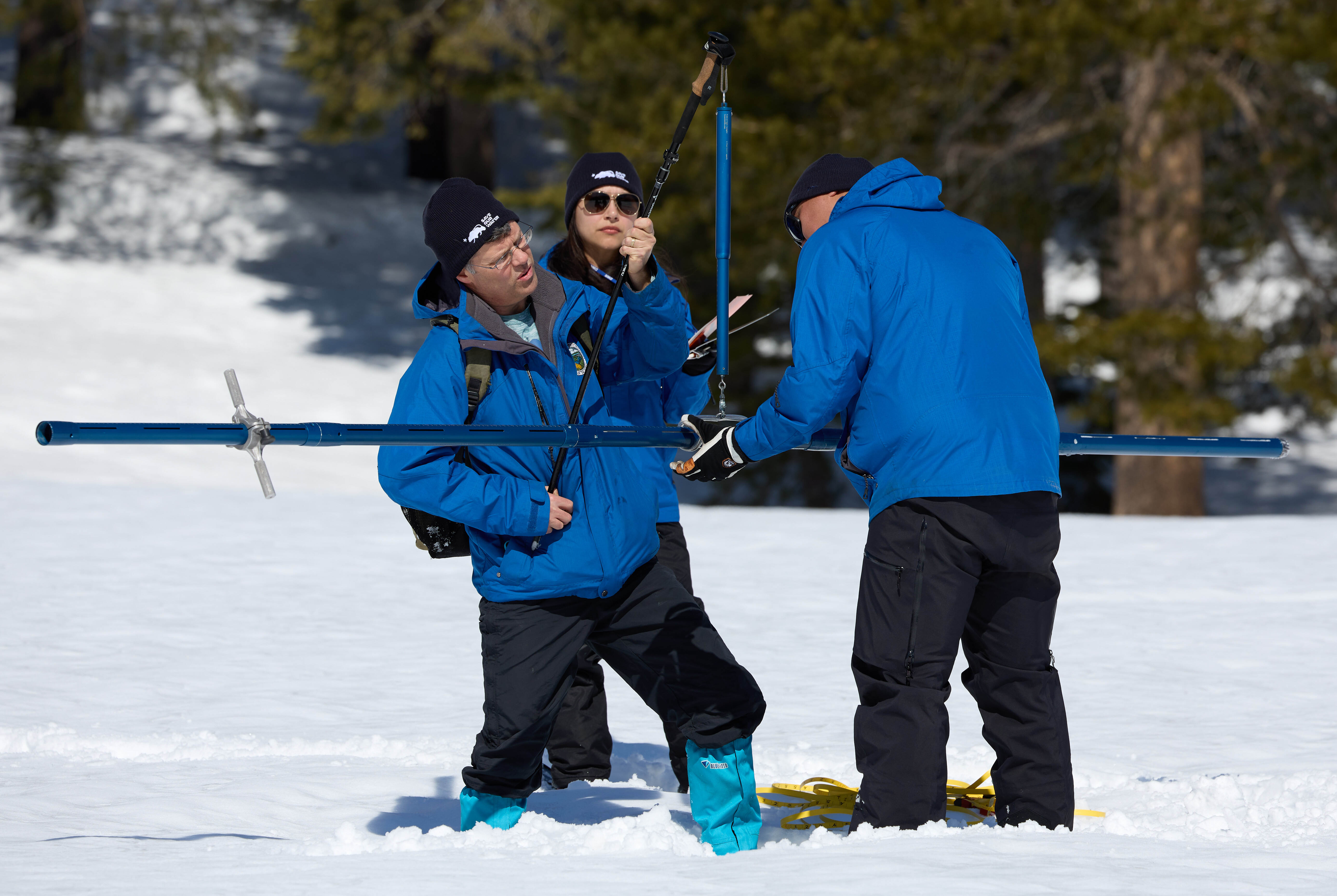 Andrew Reising left, a California Department of Water Resources Engineer in the Snow Surveys and Water Supply Forecasting Unit, Sean de Guzman, right, Manager of the California Department of Water Resources Snow Surveys and Water Supply Forecasting Unit, and Angelique Fabbiani-Leon California Department of Water Resources State Hydrometeorologist in Hydrology Section take measurements during a phase of the third media snow survey of the 2023 season at Phillips Station in the Sierra Nevada Mountains. The survey is held approximately 90 miles east of Sacramento off Highway 50 in El Dorado County. Photo taken March 3, 2023.
 
Fred Greaves / California Department of Water Resources.