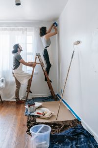 A man and a woman painting a wall