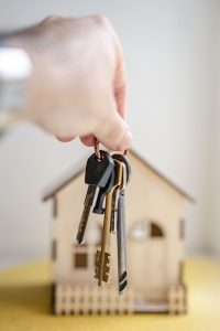 A set of keys in front of a wood house