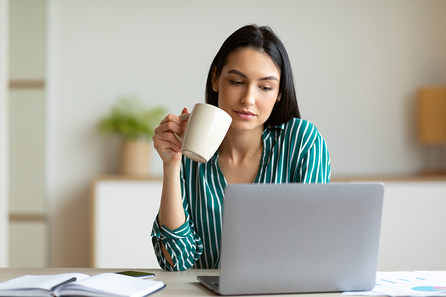 Woman at office laptop coffee