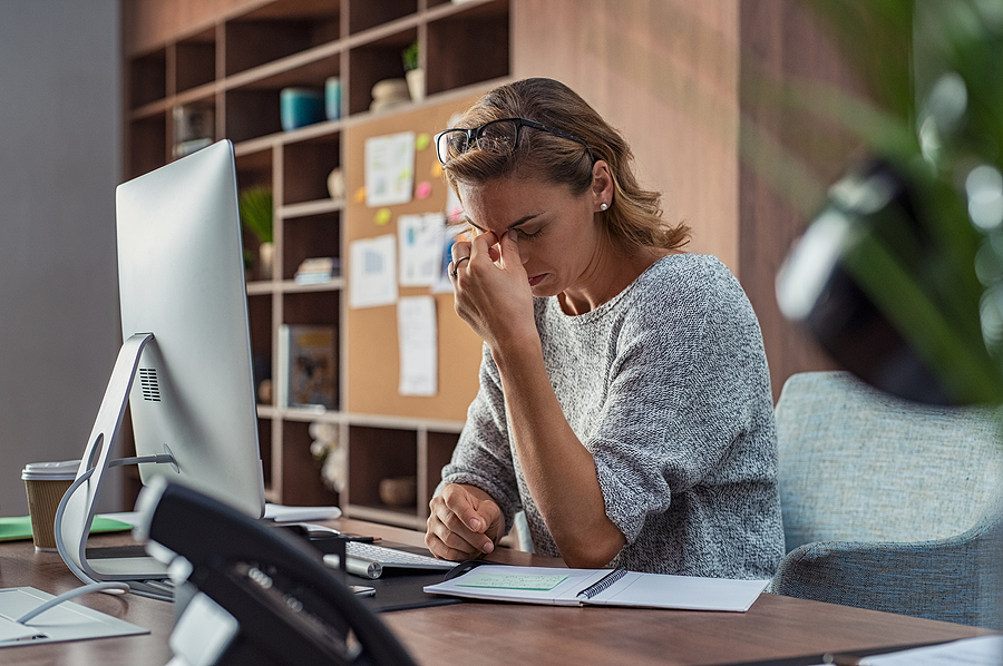 Exhausted businesswoman experiencing workplace stress