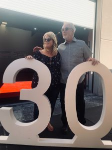 Photo of Terry Carson, owner of Carson's Coatings standing with her 25 year employe, Bobby Williams next to a large "30" sign (made by Carson's Coatings) for their 30th year in business - June 24 2021