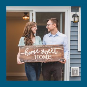 a couple holding a home sweet home sign