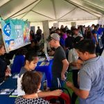 people at job fair in outdoor tent