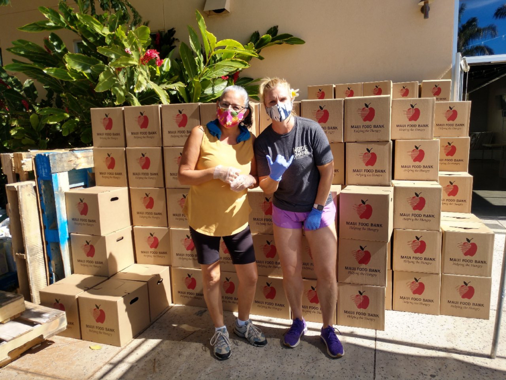 RAM members Rosalind Link (left) and Alana Rucynski help distribute boxes of food drive-thru-style at Hope Chapel in Kihei, one of several large-scale food distribution sites on Maui.