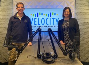 Rachel and Mike stand infront of Velocity logo
