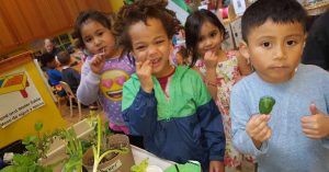 Three children taste kale at Daybreak Star Preschool with chef Andre Laranang