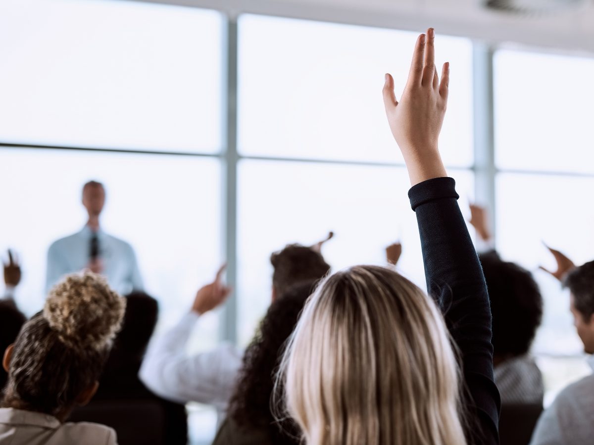 Business people raising their hands to ask a question