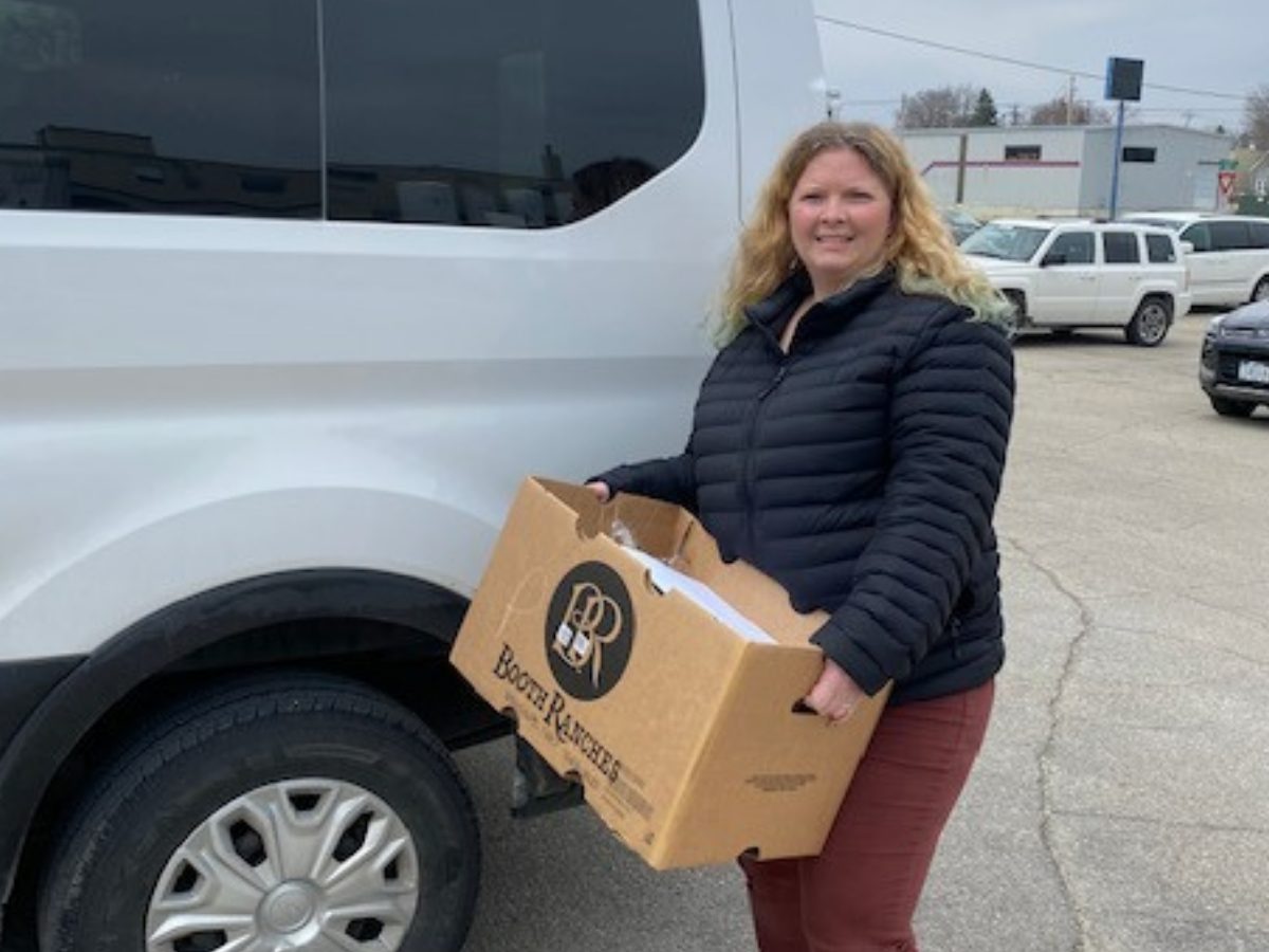 North Iowa Community Action staff member carries box of CACFP foods