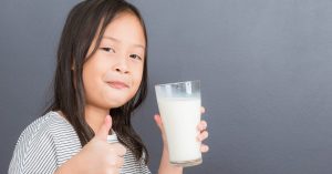 CACFP participant drinks from a glass of milk