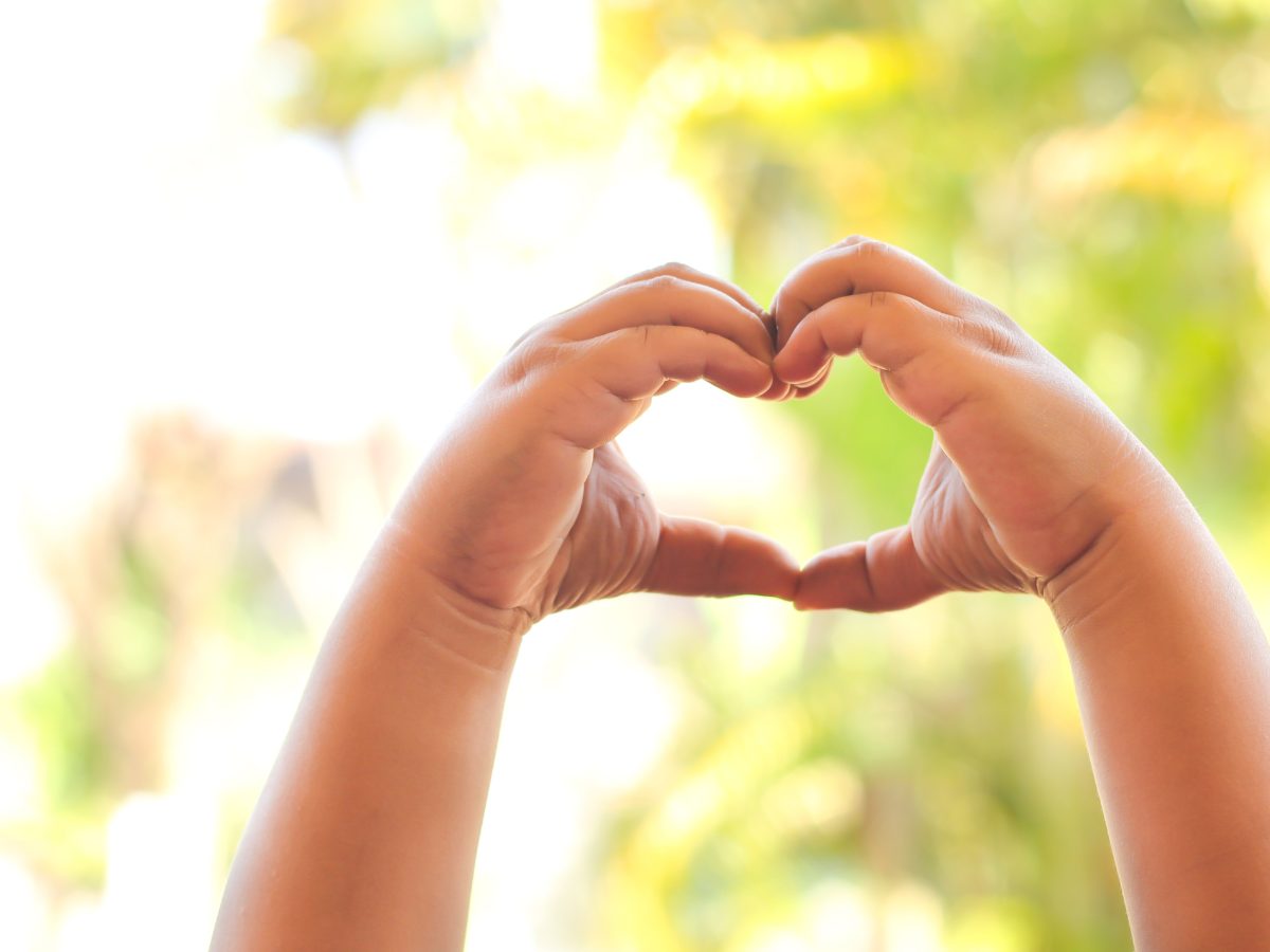 CACFP participant child hands making heart symbol