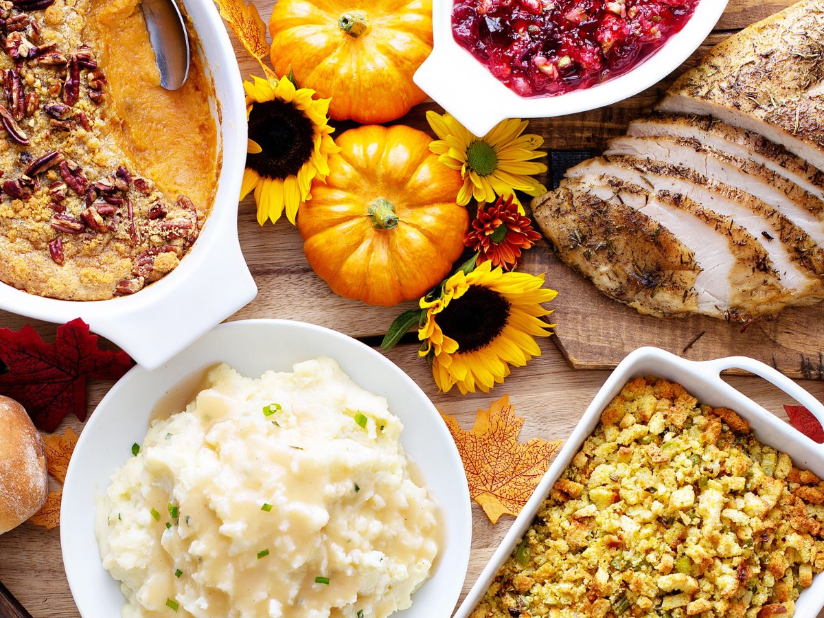 A delicious spread of CACFP creditable dishes, including sweet potatoes, mashed potatoes, stuffing, turkey and cranberry relish.