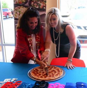 Redcoat member slicing a pizza at an event