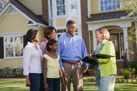 Real estate agent showing a house to family