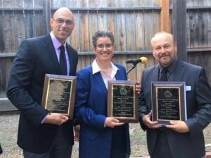 Three people with awards