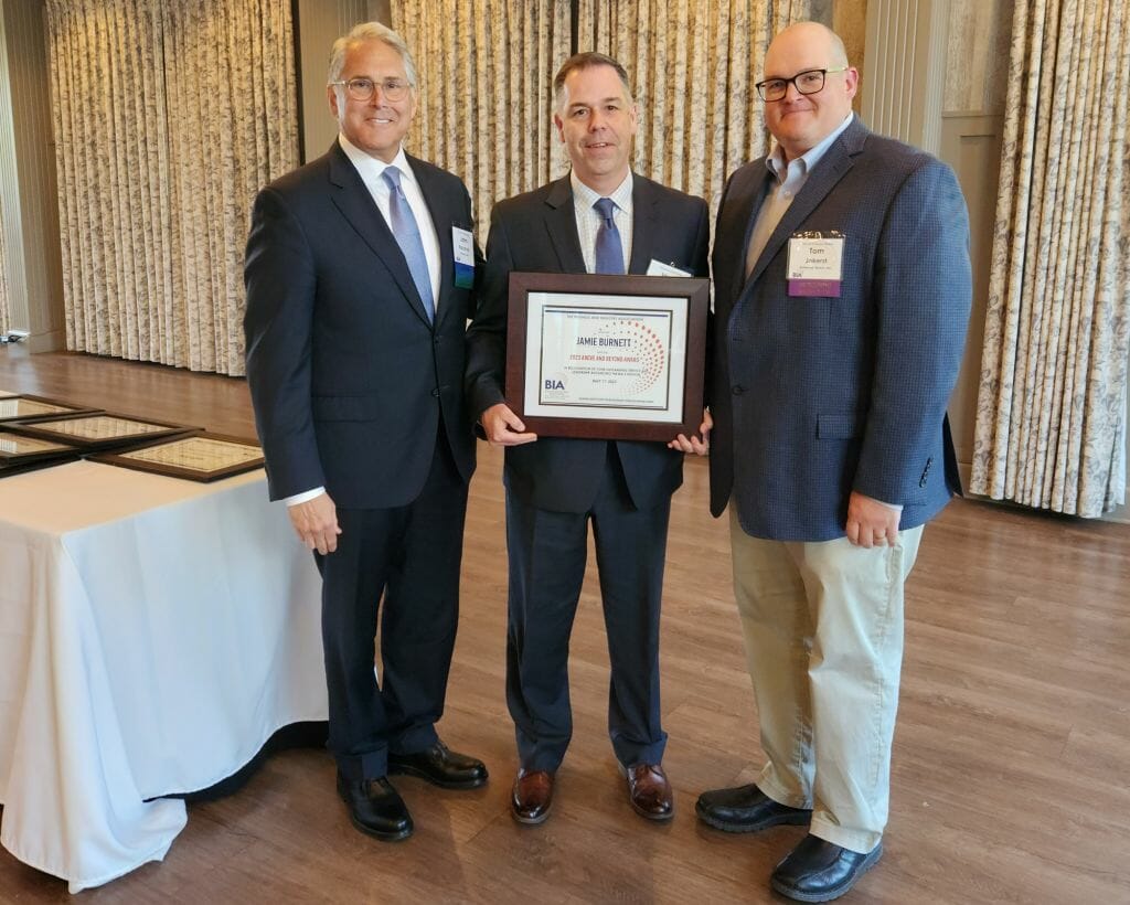 Jamie Burnett, president of Sight Line Public Affairs, receives the Business &amp; Industry Association’s Above and Beyond Award at BIA’s Annual Business Meeting at LaBelle Winery in Derry Wednesday, May 17. New BIA Chair John Kacavas, left, and outgoing Chair Tom Jokerst present the award. (Courtesy photo)