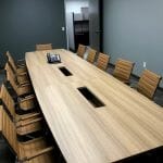 A neat and clean office room with a long office table and chairs for 10 people to sit at