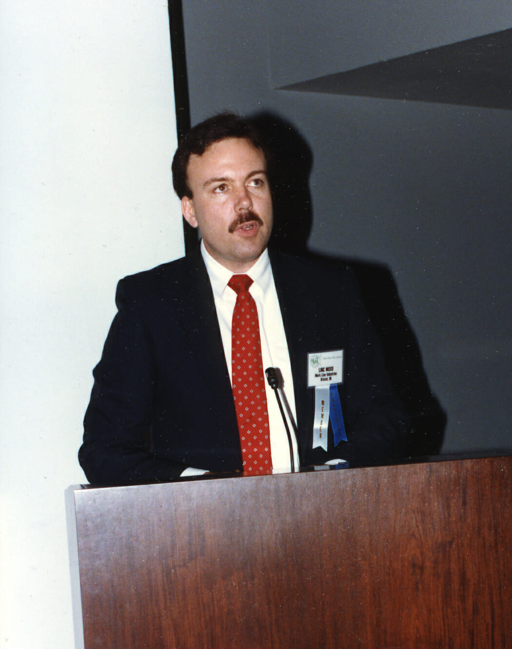 Linc Moss s'adresse aux participants de la convention annuelle et du salon MMOA de 1987.