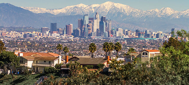 Snowed peaks mountains and downtown Los Angeles cityscape