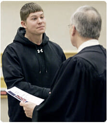 Rock County Circuit Court Judge James P. Daley congratulates Casey Johnson of Beloit, Wisconsin's first Veterans Treatment Court graduate. Photo courtesy of the Janesville Gazette