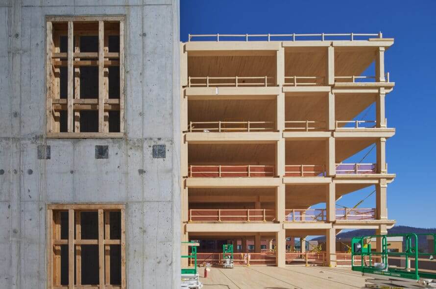 Side-of-concrete-stairwell-attached-to-wooden-frame-building