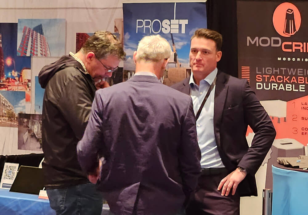 Synergy Modular CEO Justin Stewart speaks with other exhibitors and attendees at the Offsite Construction Summit.