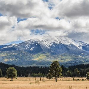 Flagstaff mountain view with snowy peaks and cloud coverage.
