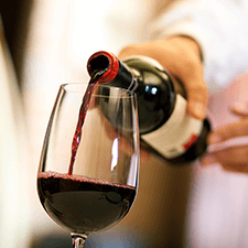 WINERIES-&-VINEYARDS red wine poured from the bottle into a wine glass