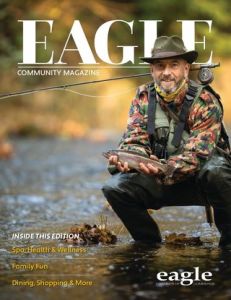 magazine cover of man holding fish by a stream