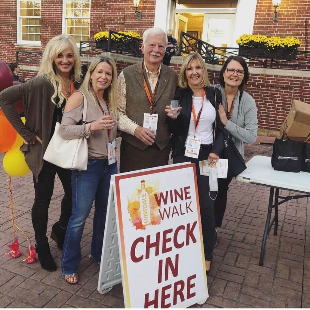 people in front of a wine walk sign