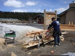 carpenter using saw next to outdoor exhibit