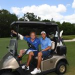 2 men in a golfcart