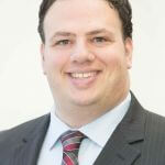 Headshot photo of Dan Deutsch wearing a suit and tie