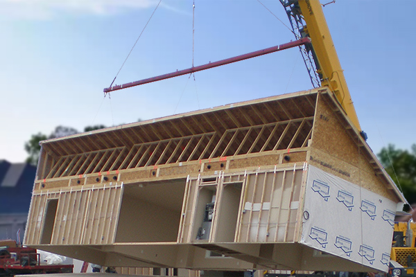 modular home lifted with construction equipment