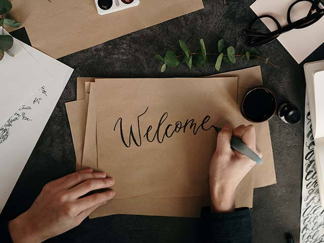 hand writing welcome on brown paper