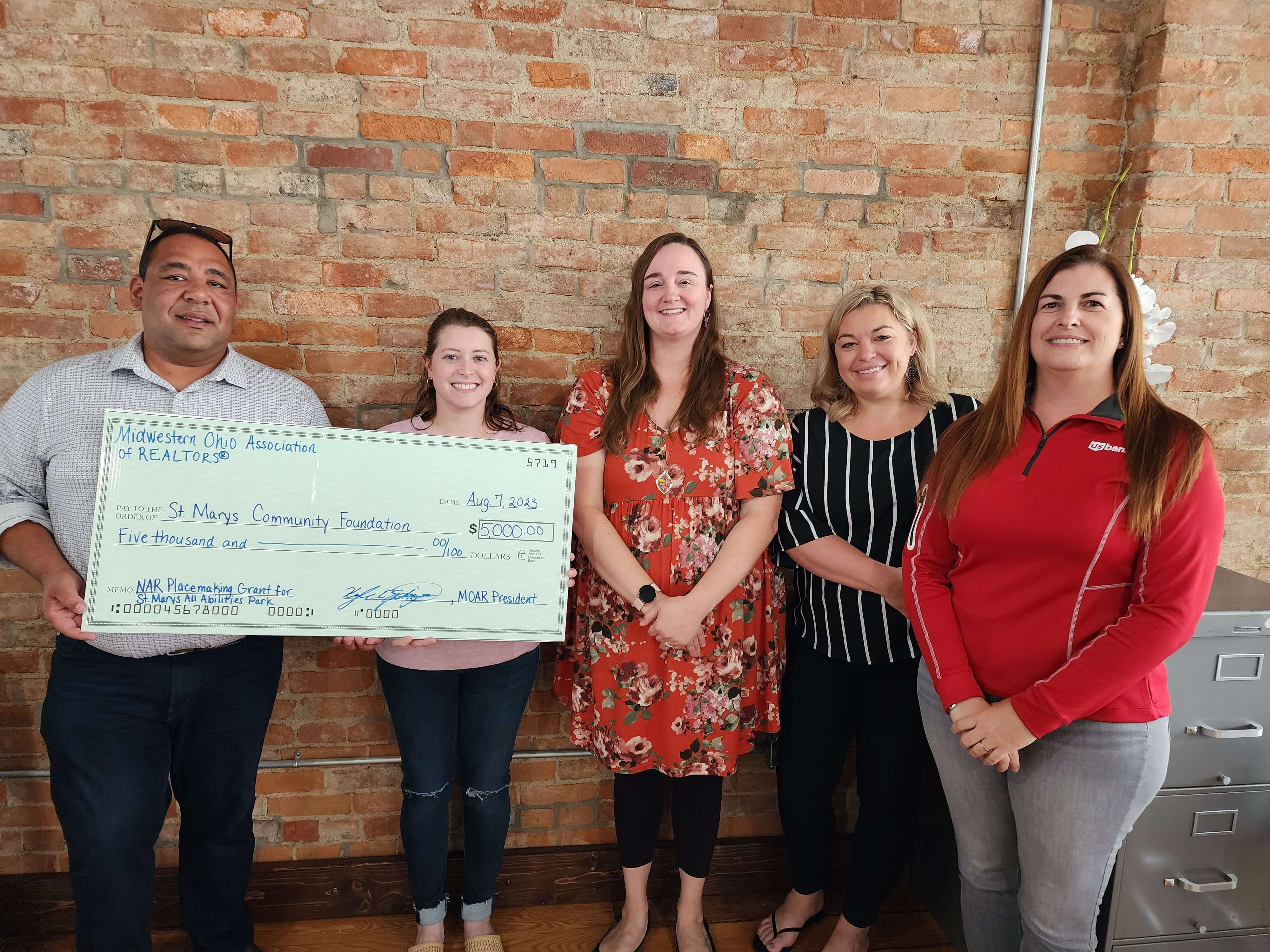 MOAR President, Kyle Springs, presents check to Ashley Randolph for St. Marys Community Foundation for the St. Marys All Abilities Park project along with MOAR Association Executive, Megan Wise, MOAR Director, Krista Hubbell, and MOAR Affiliate Member and supporter of the project, Amy Frilling