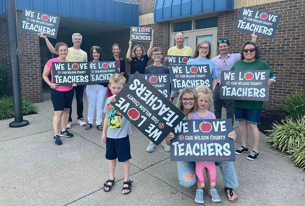 Elementary School Kids Holding We Love Our Teachers Signs