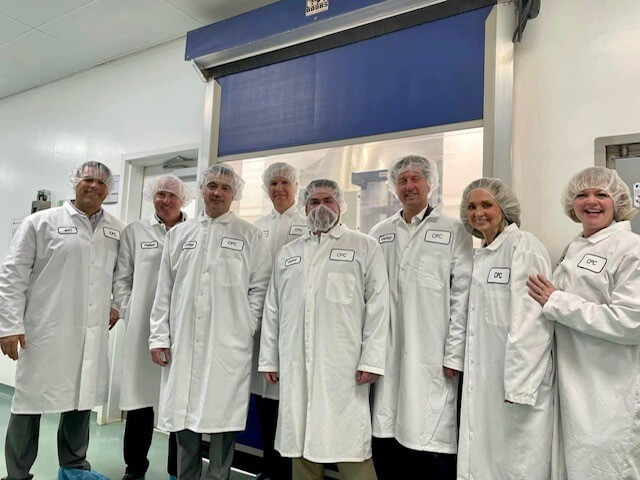 group in white lab gear posing for photo