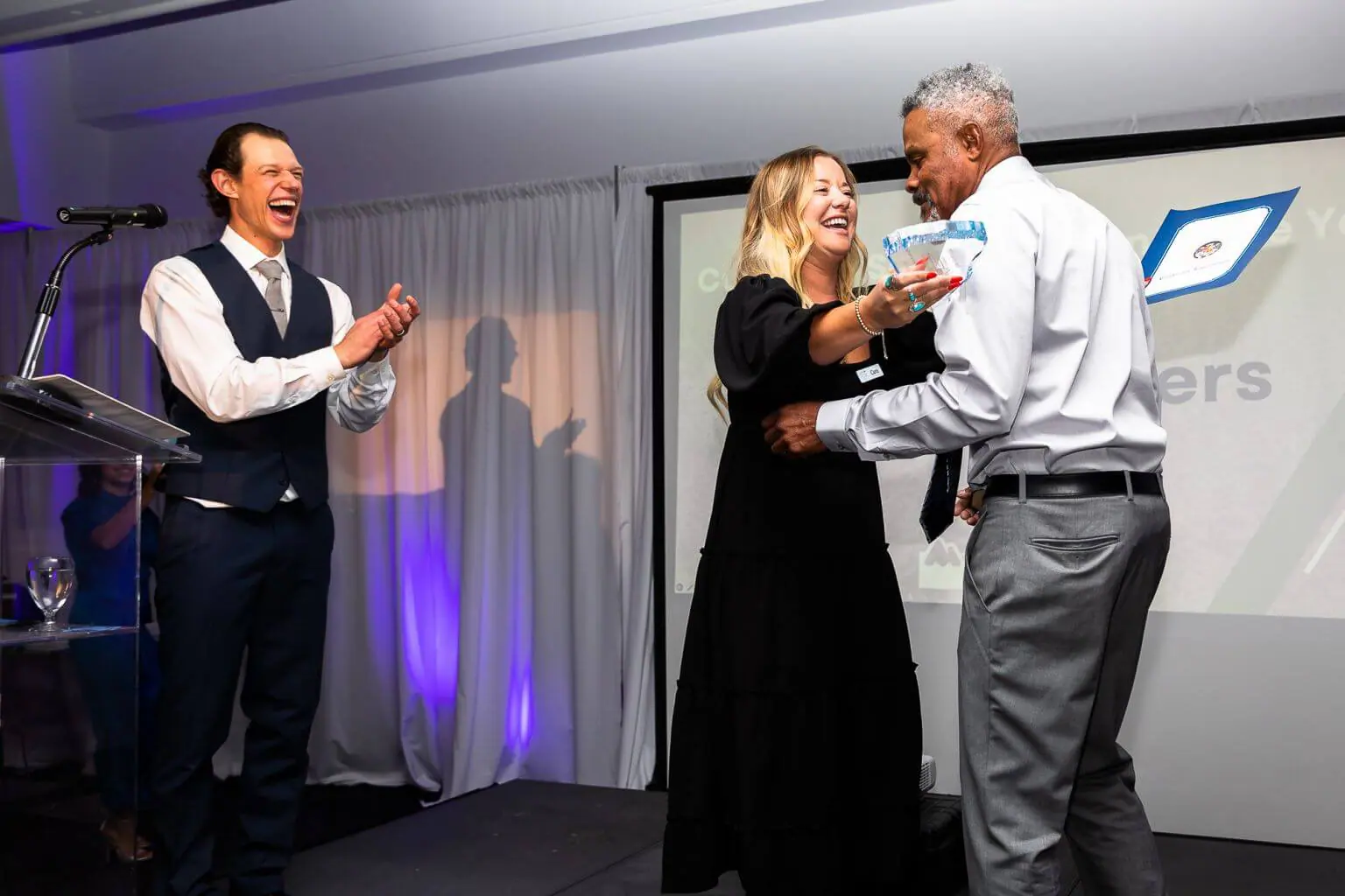 Vons employee Lamont Peters accepts the Customer Service Person of the Year award from Cara Ferguson and Jeremy Goico