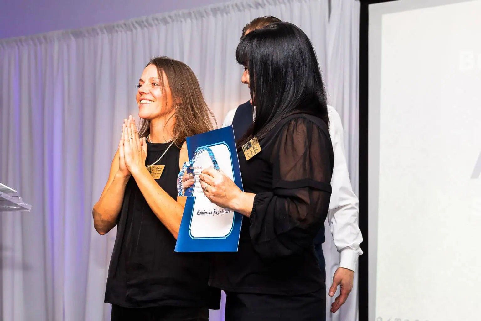 Stellar Brew owner Andrea Walker wins Business Person of the year - she's smiling with her hands clasped in gratitude